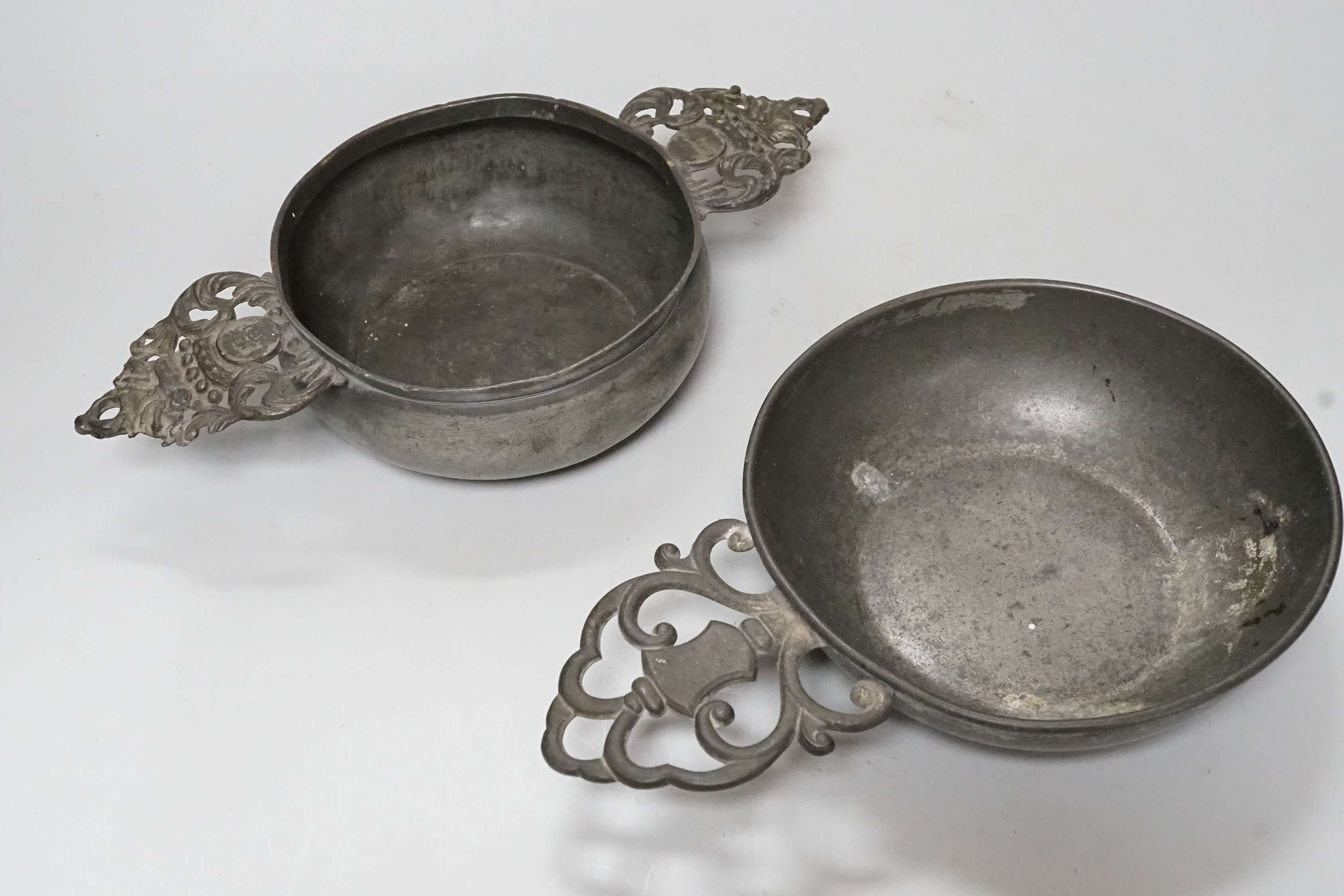 An 18th century French pewter two handled ecuelle, lacking cover, and one other, largest 27cm wide, (2)